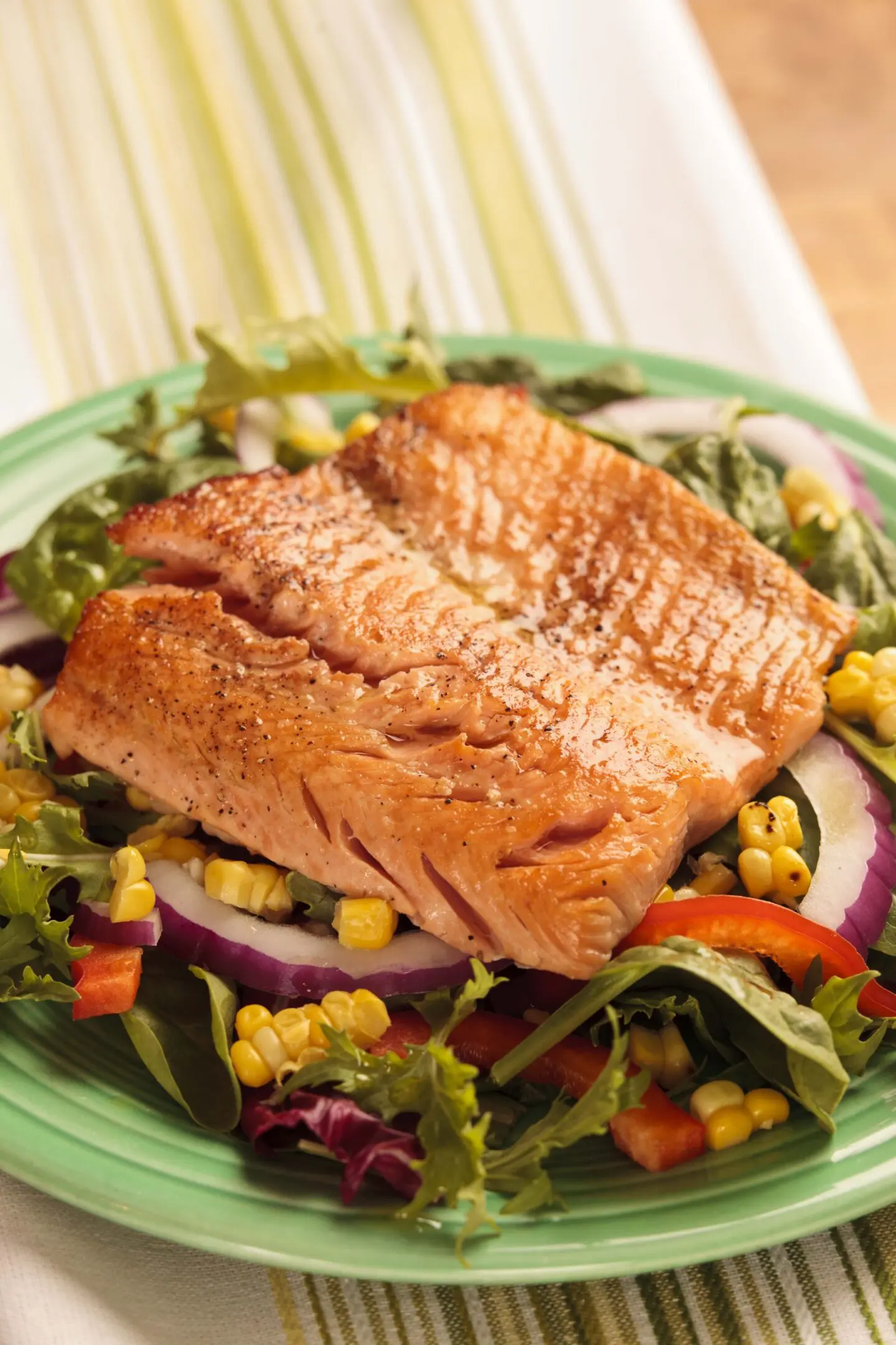 Grilled salmon on a colorful vegetable salad.