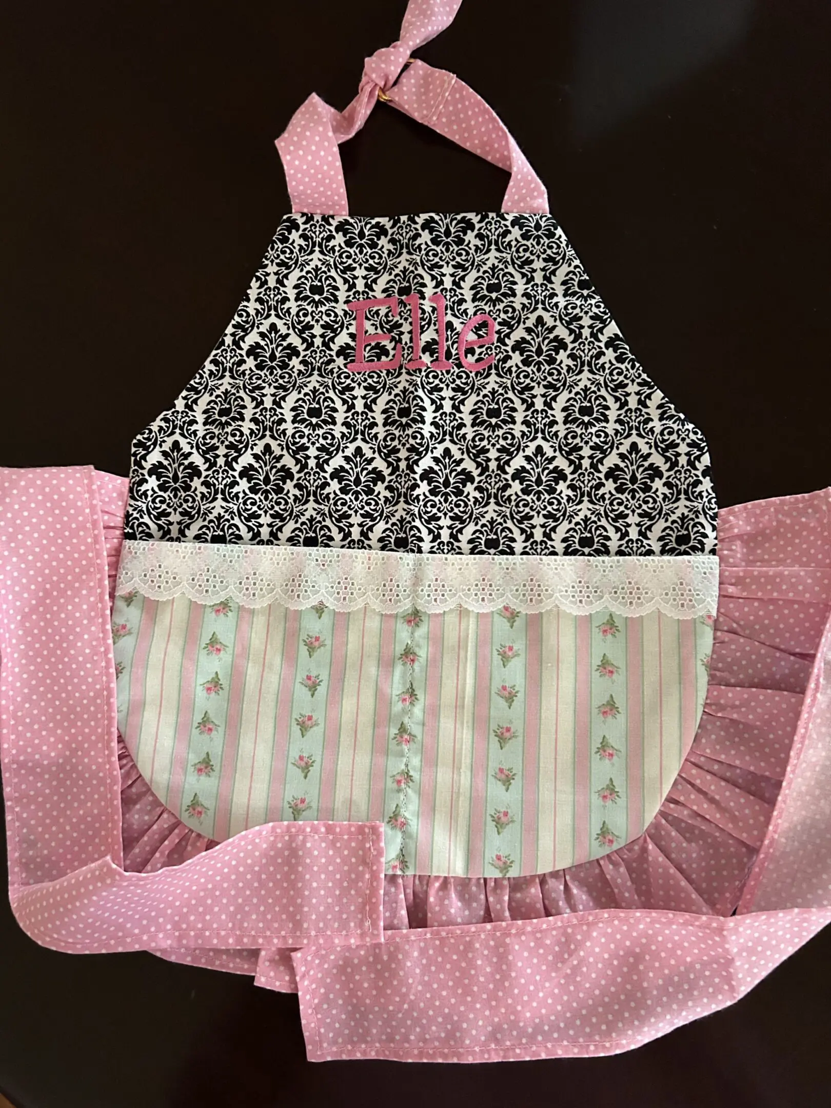Pink and black patterned apron with name.
