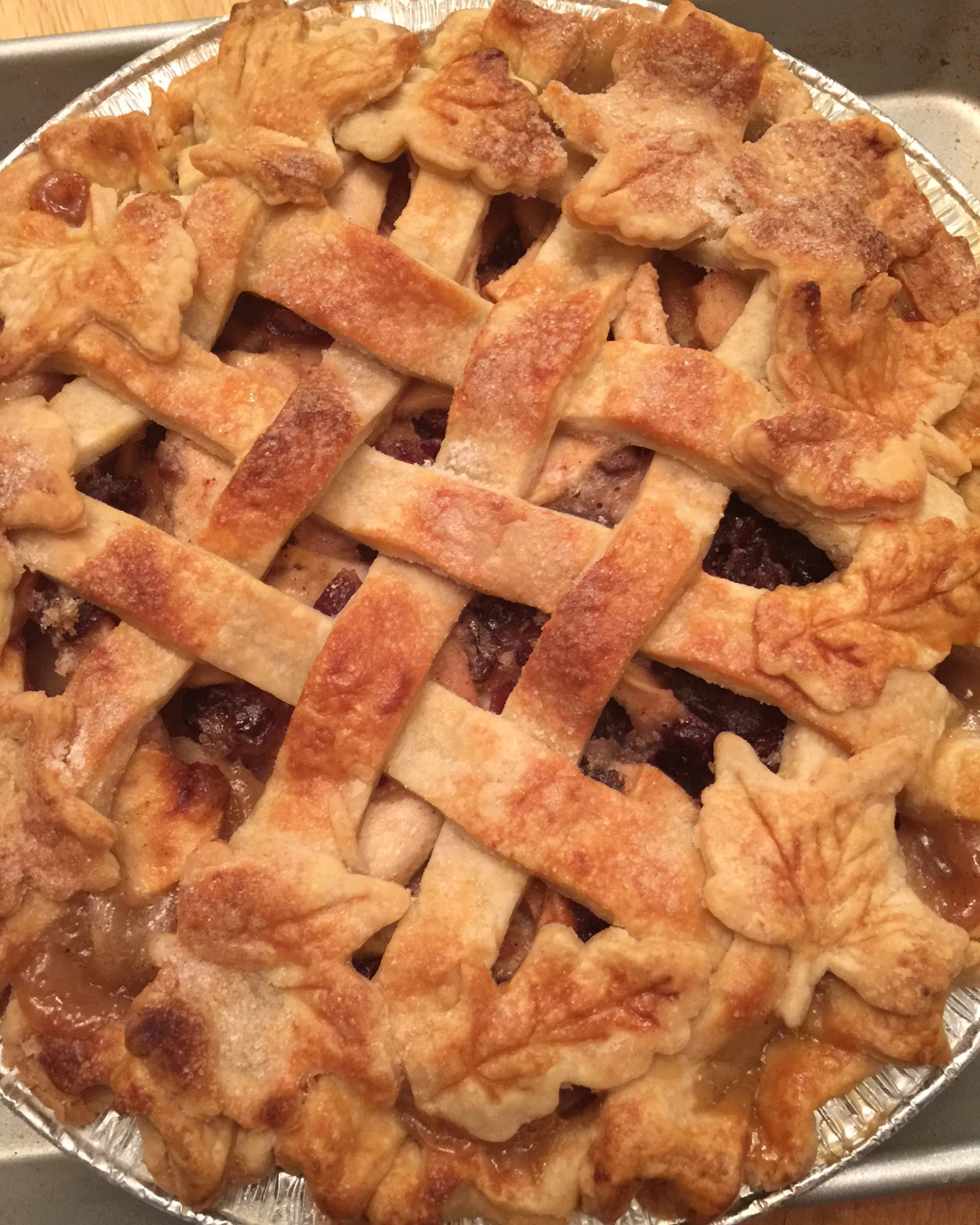 Lattice apple pie with decorative leaf crust.