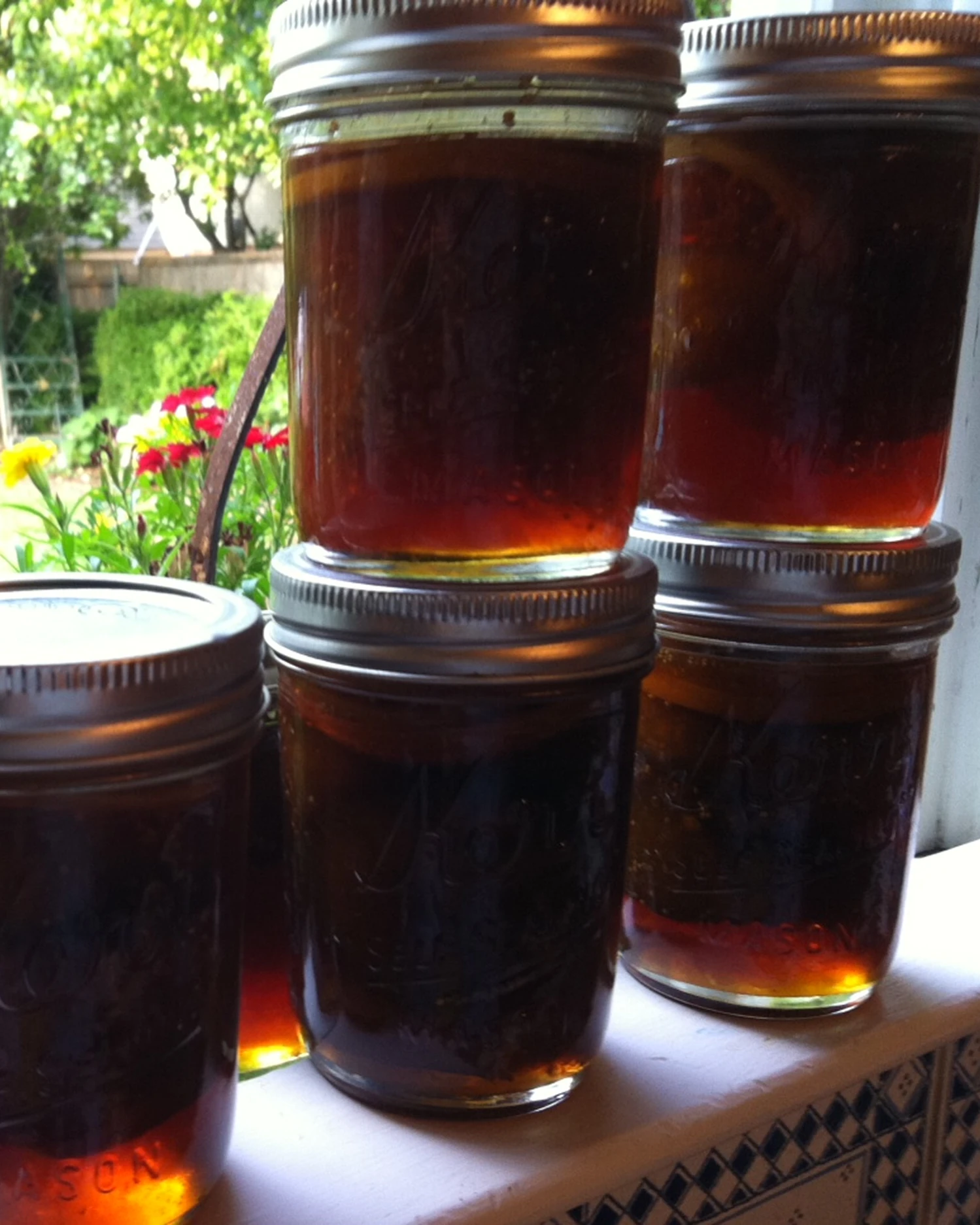 Jars of amber-colored liquid on shelf.
